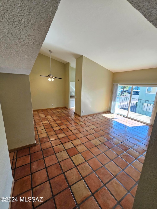 unfurnished living room featuring a textured ceiling, tile patterned floors, ceiling fan, and lofted ceiling