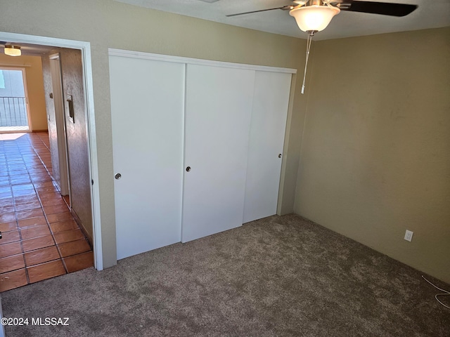 unfurnished bedroom with carpet flooring, ceiling fan, and a closet