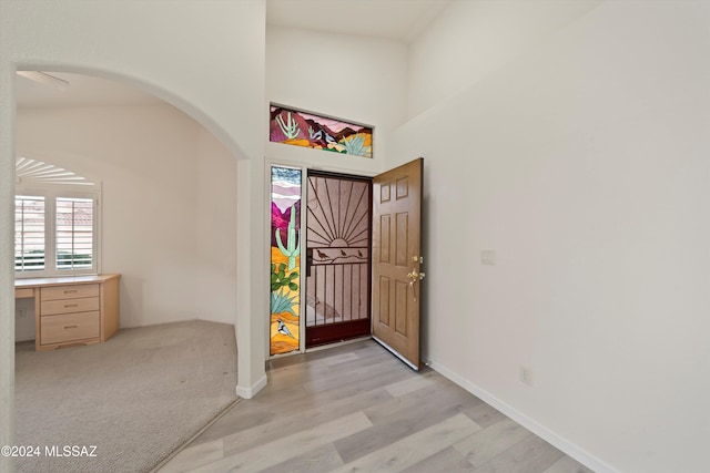 foyer entrance featuring light hardwood / wood-style flooring and lofted ceiling