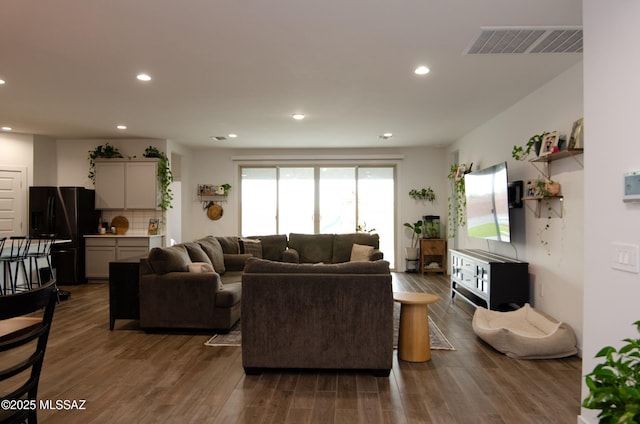 living room with visible vents, recessed lighting, and wood finished floors