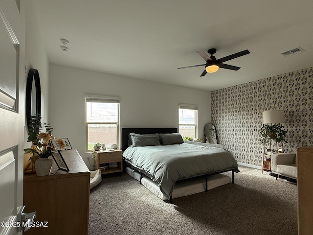 bedroom featuring visible vents, a ceiling fan, carpet, wallpapered walls, and baseboards