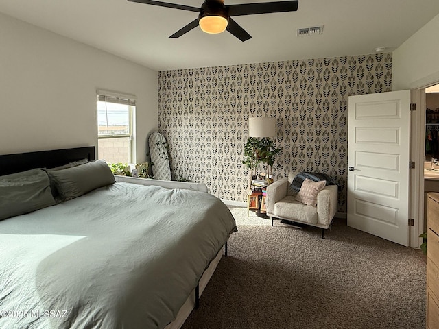 carpeted bedroom with wallpapered walls, visible vents, and ceiling fan