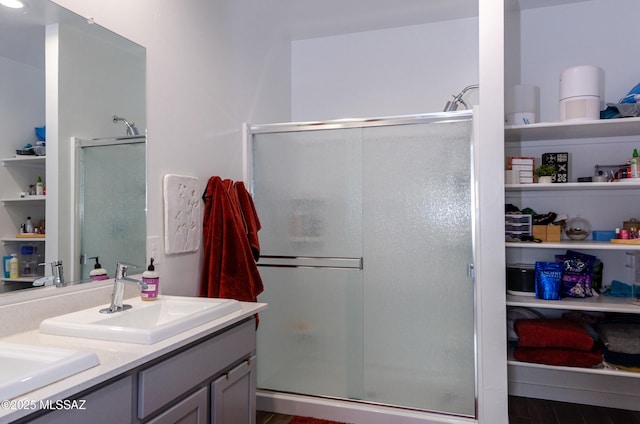 bathroom featuring hardwood / wood-style floors, vanity, and a shower with shower door