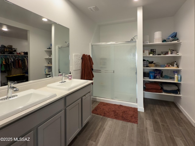 bathroom featuring wood-type flooring, vanity, and walk in shower