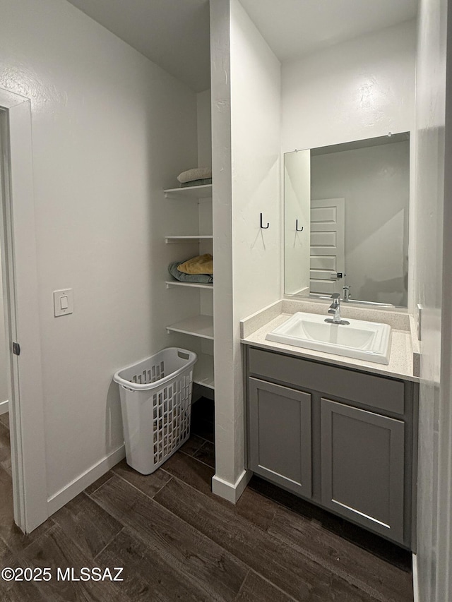 bathroom featuring vanity, baseboards, and wood finished floors