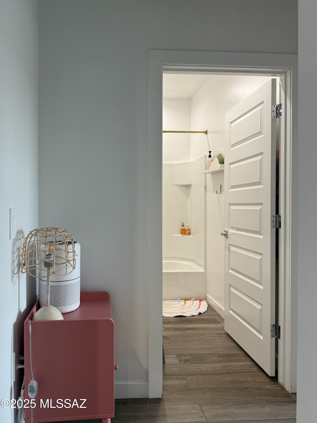 hallway featuring baseboards and wood finished floors