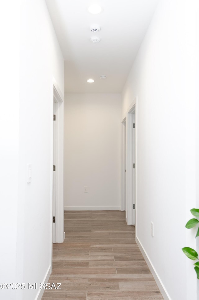 hall featuring recessed lighting, light wood-type flooring, and baseboards