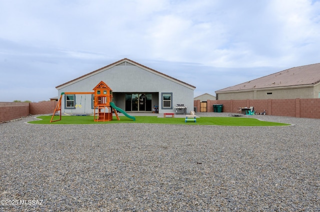 back of property with a patio, a playground, and a fenced backyard