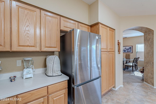 kitchen with stainless steel refrigerator, light brown cabinets, and light tile patterned flooring