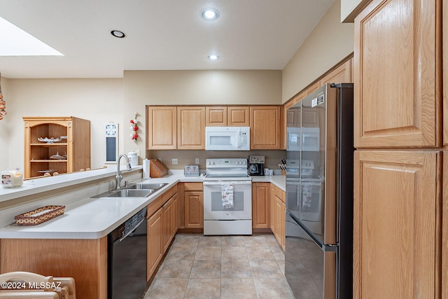 kitchen with white appliances, sink, light tile patterned floors, light brown cabinetry, and kitchen peninsula