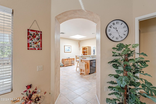 hall featuring light tile patterned flooring and sink