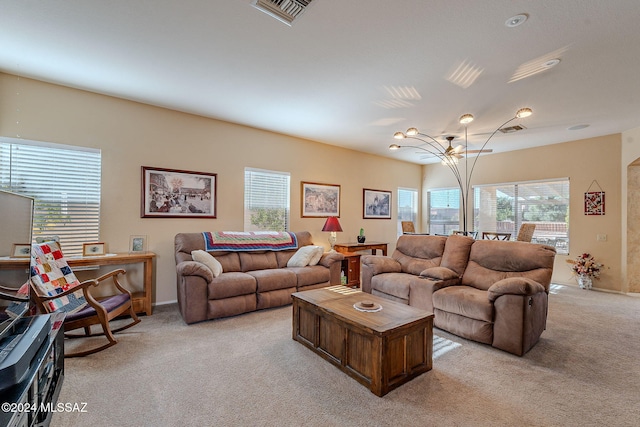 living room with light carpet, a chandelier, and plenty of natural light