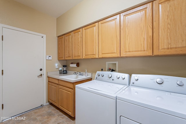 clothes washing area with washing machine and clothes dryer, sink, light tile patterned flooring, and cabinets