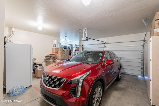 garage featuring white refrigerator and a garage door opener