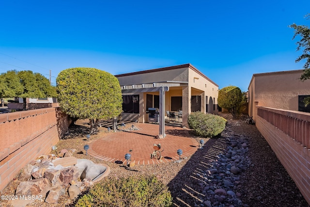 back of property featuring a patio area and a pergola