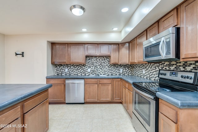 kitchen featuring backsplash, sink, light tile patterned floors, and stainless steel appliances