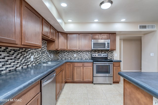 kitchen featuring light tile patterned floors, sink, appliances with stainless steel finishes, and tasteful backsplash