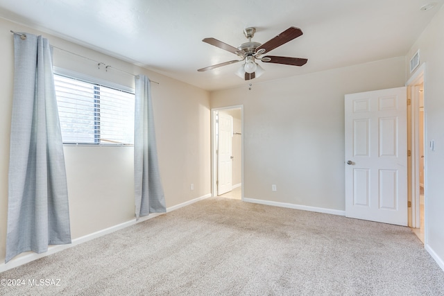 carpeted spare room featuring ceiling fan