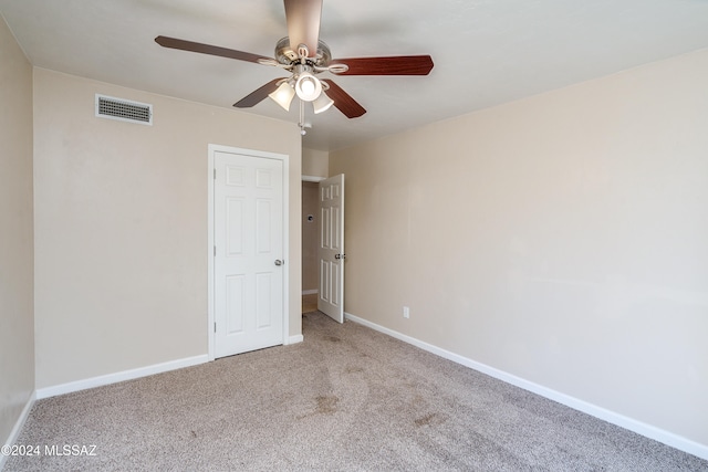 spare room featuring light colored carpet and ceiling fan