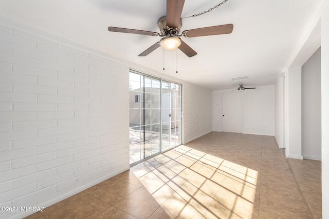 unfurnished room featuring light tile patterned floors and brick wall