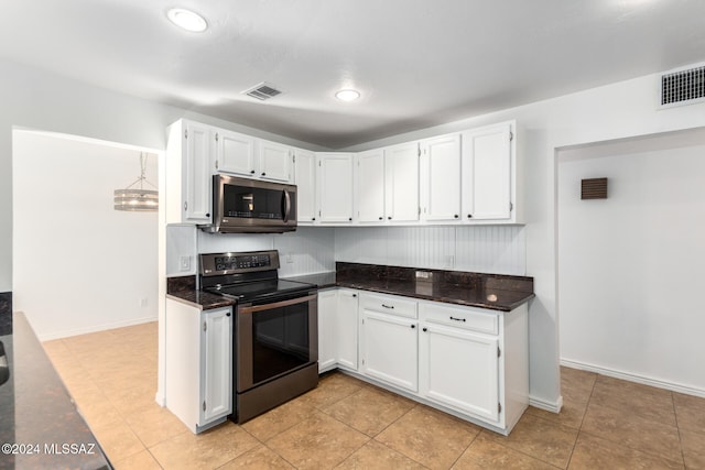 kitchen featuring black / electric stove, light tile patterned flooring, white cabinets, and dark stone counters