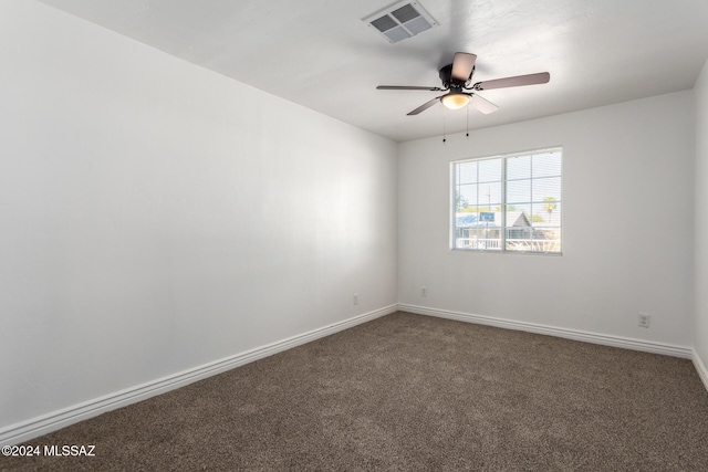 empty room featuring dark carpet and ceiling fan