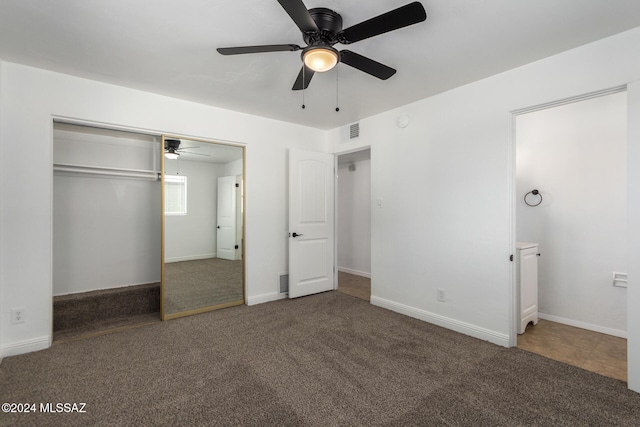 unfurnished bedroom with ceiling fan, dark carpet, and a closet