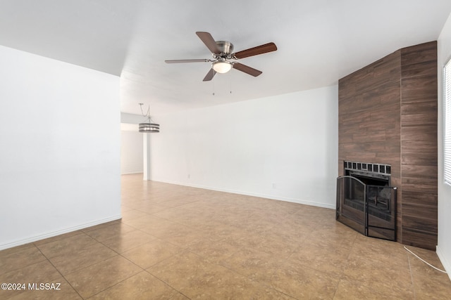 unfurnished living room with ceiling fan and a tiled fireplace