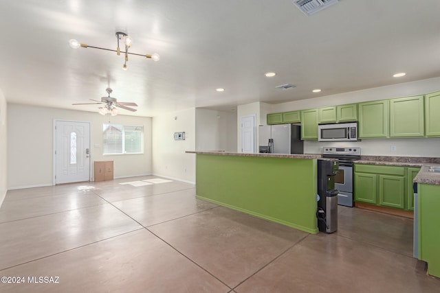 kitchen featuring green cabinetry, a kitchen island, ceiling fan with notable chandelier, and appliances with stainless steel finishes