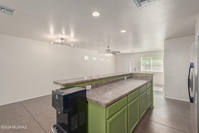 kitchen with a center island, green cabinetry, ceiling fan, light tile patterned floors, and white fridge