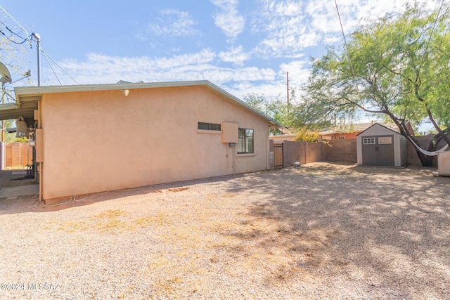 rear view of property with a storage unit