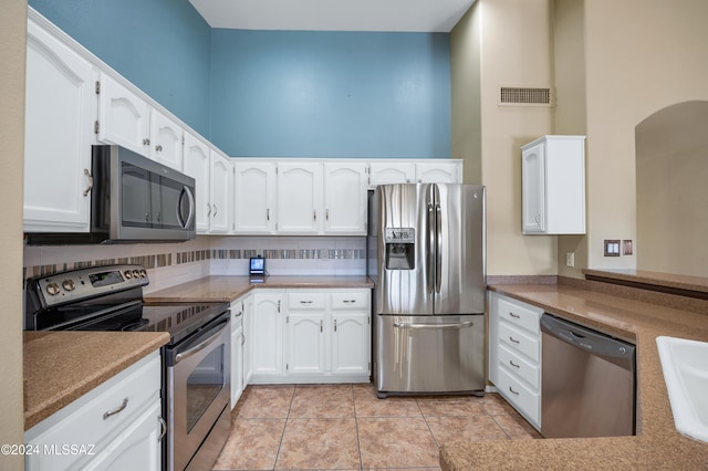 kitchen with sink, white cabinetry, stainless steel appliances, and light tile patterned floors