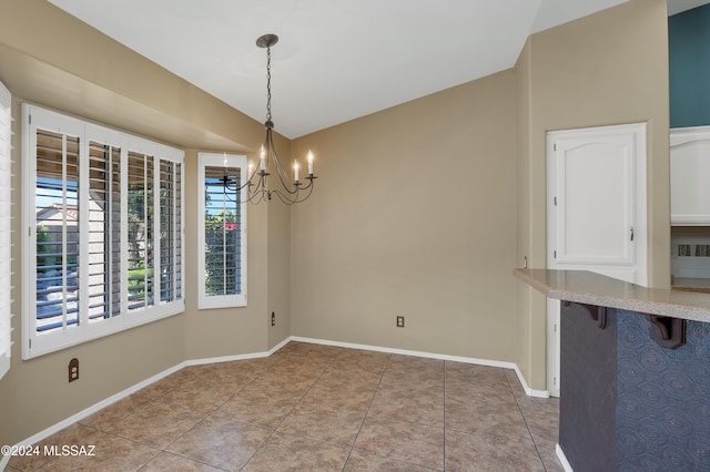 unfurnished dining area with an inviting chandelier and light tile patterned flooring