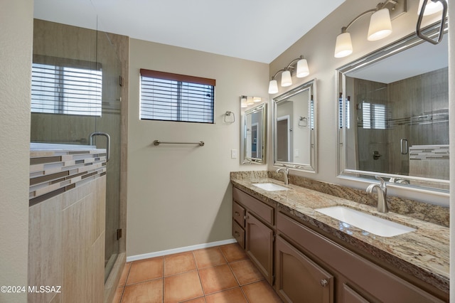 bathroom with tile patterned floors, a shower with door, and vanity