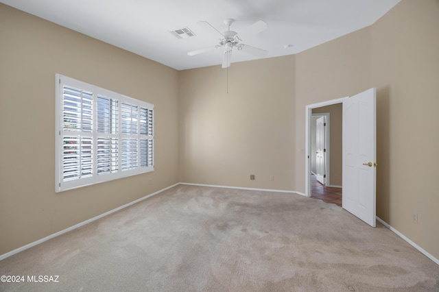 carpeted spare room with ceiling fan