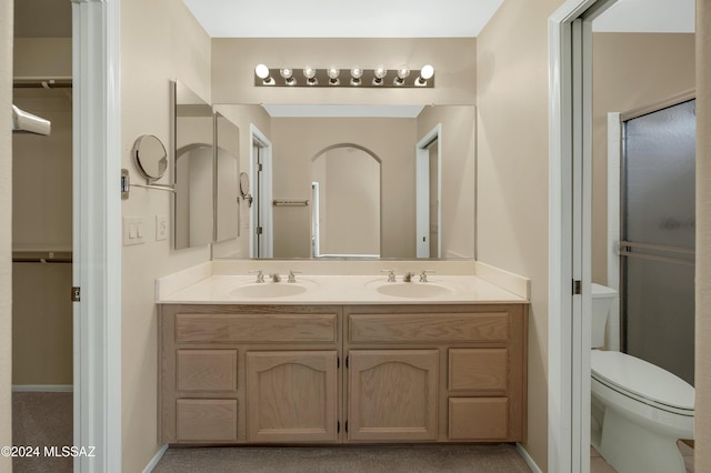 bathroom featuring vanity, an enclosed shower, and toilet