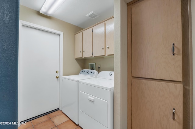 laundry area with cabinets, washing machine and clothes dryer, and light tile patterned flooring