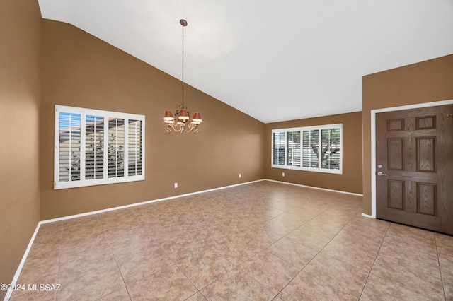 foyer entrance with an inviting chandelier, light tile patterned floors, and vaulted ceiling