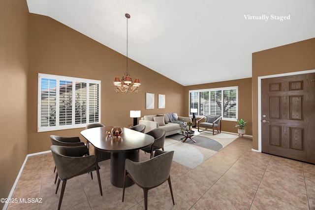 dining area with light tile patterned floors, an inviting chandelier, and lofted ceiling