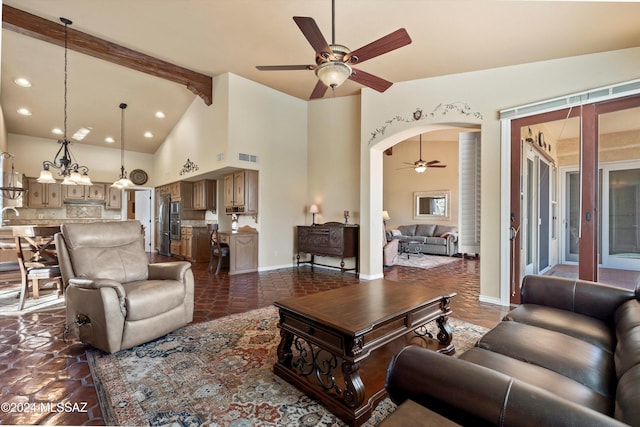 living room featuring beamed ceiling, high vaulted ceiling, and ceiling fan with notable chandelier