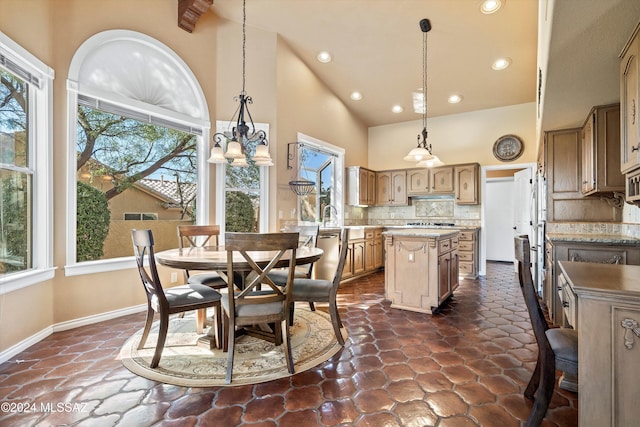 dining room with a notable chandelier, a wealth of natural light, and high vaulted ceiling