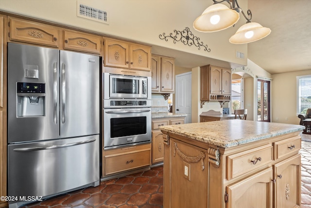 kitchen with vaulted ceiling, pendant lighting, a center island, light stone counters, and stainless steel appliances