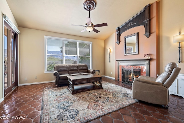 living room featuring lofted ceiling, a fireplace, and ceiling fan