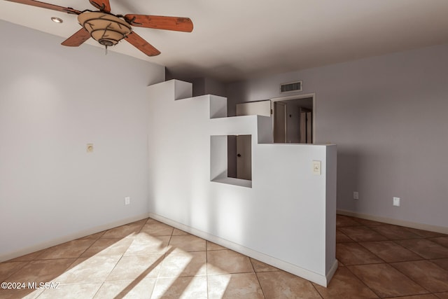 spare room with ceiling fan and light tile patterned flooring