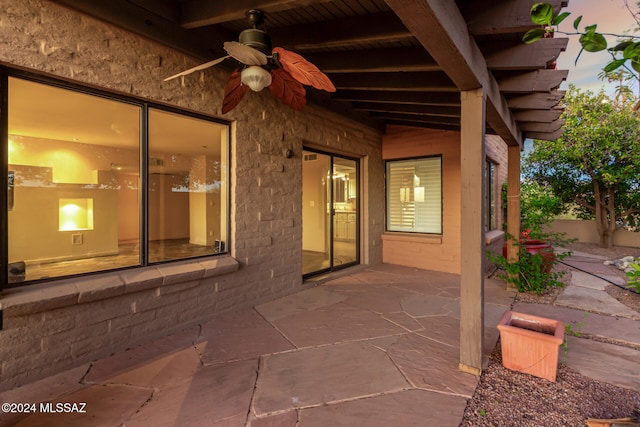 patio terrace at dusk featuring ceiling fan