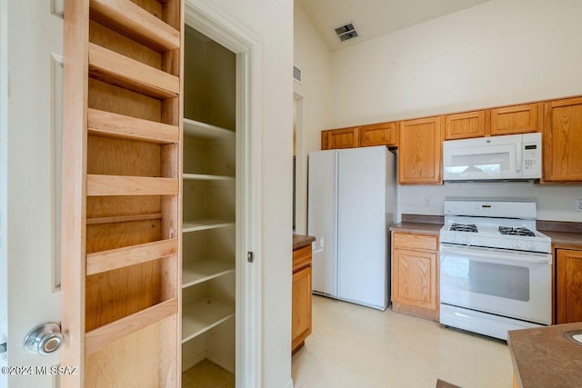 kitchen featuring white appliances and lofted ceiling