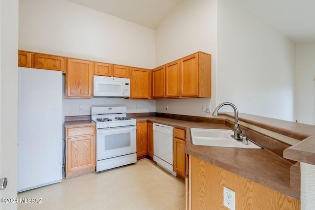 kitchen featuring white appliances, high vaulted ceiling, and sink