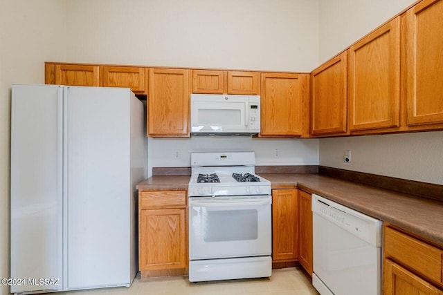 kitchen with light tile patterned flooring and white appliances