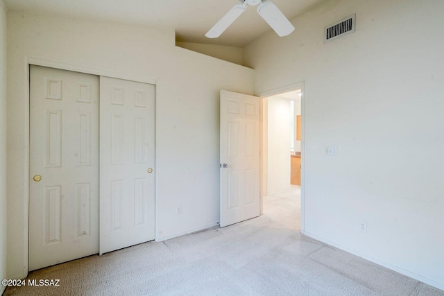 unfurnished bedroom with a closet, vaulted ceiling, ceiling fan, and light colored carpet