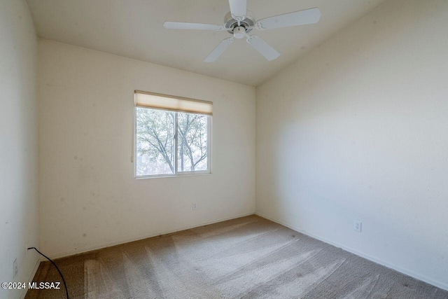 carpeted spare room with ceiling fan and lofted ceiling